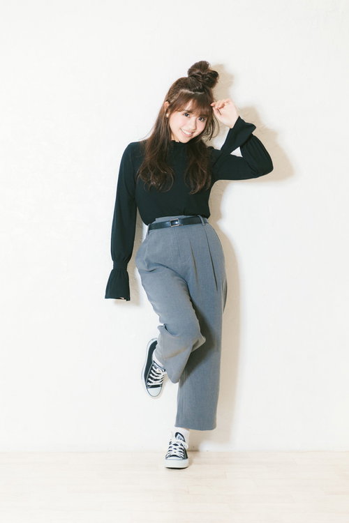 盛れる角度でポージングする緑色ニット姿の女性