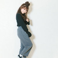 秋物の緑色トップスとワイドパンツを着た小柄な女性の笑顔の写真