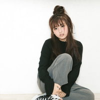 膝を抱えて座るうつろげな表情の若い女性、落ち込んだ様子の写真