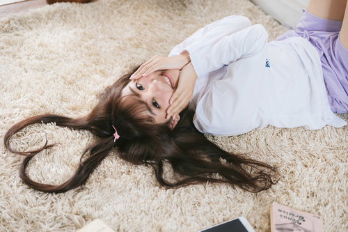 髪の毛でハートのかたちをつくる笑顔の女子