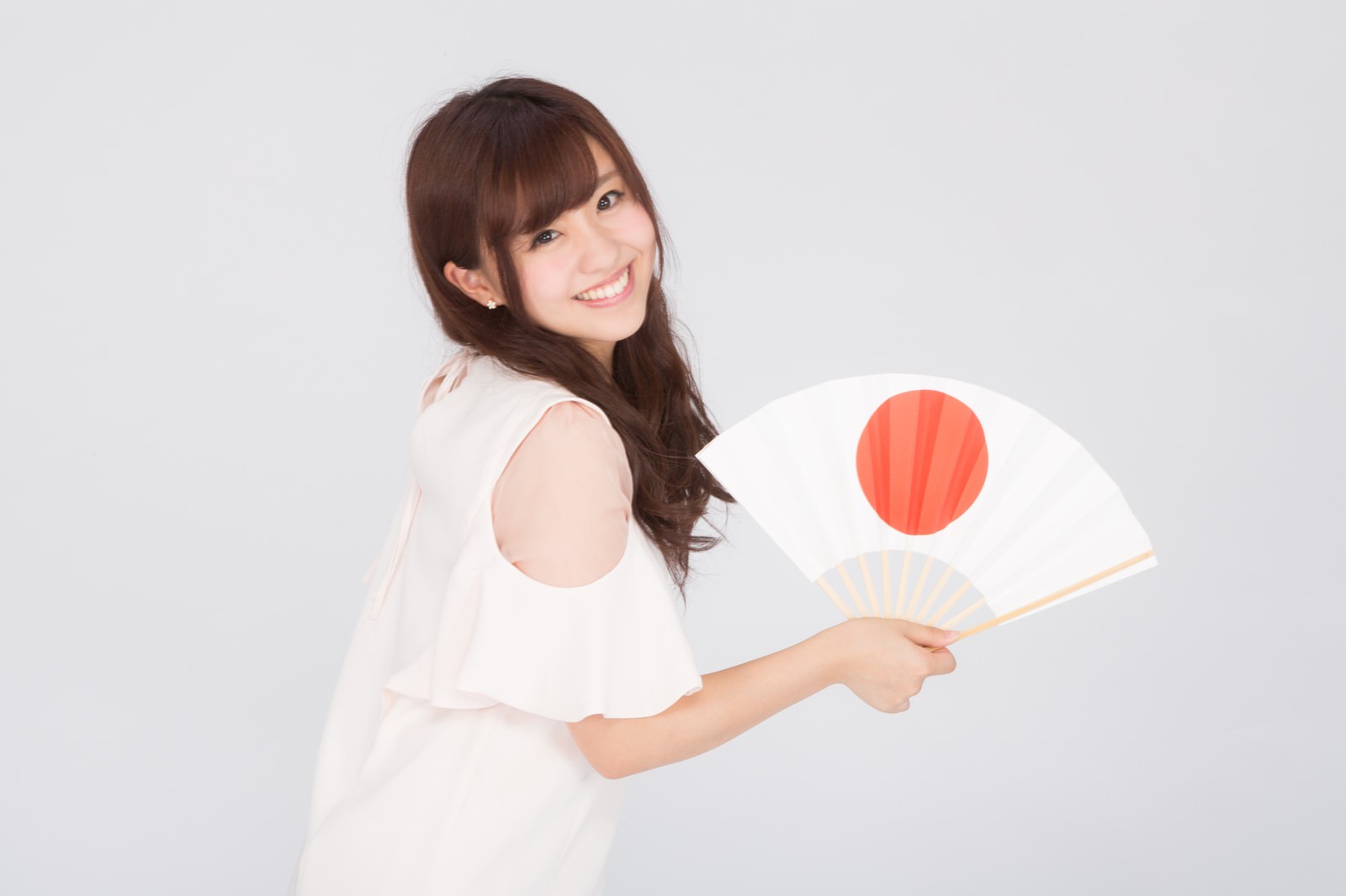日の丸の扇子を掲げて笑顔の長髪女性［モデル：河村友歌］