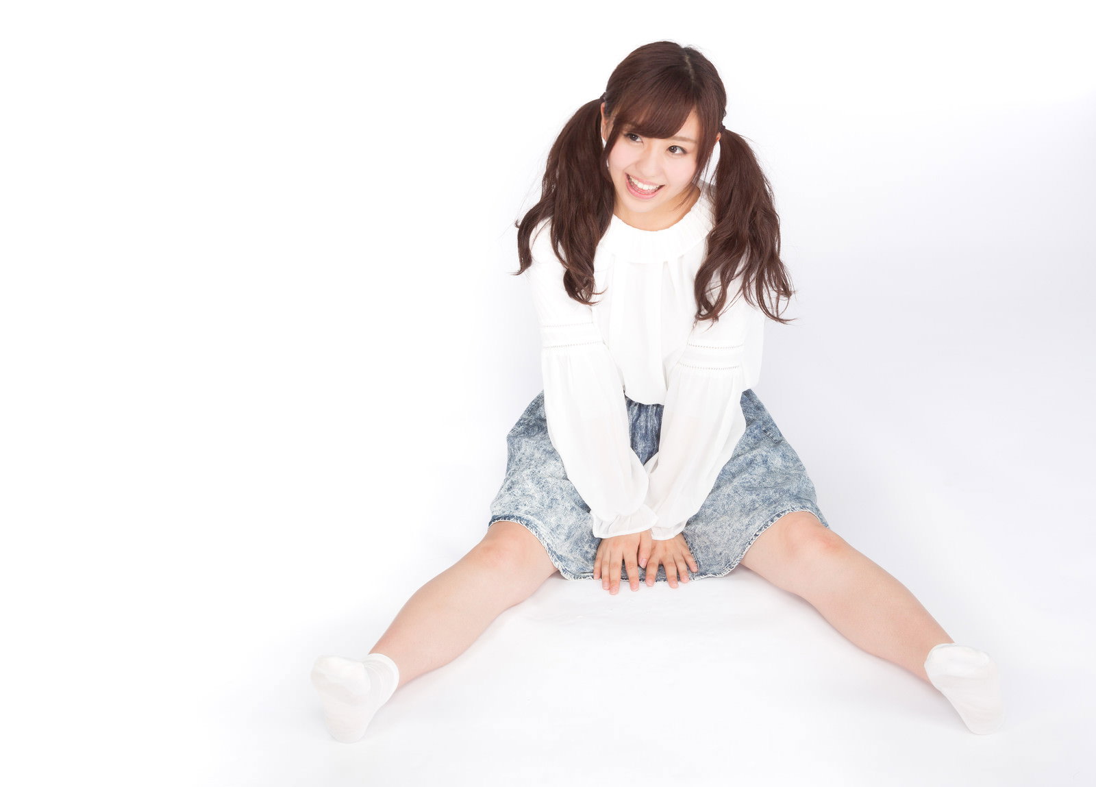 白いシャツとデニム姿で床に座り笑顔の女性［モデル：河村友歌］