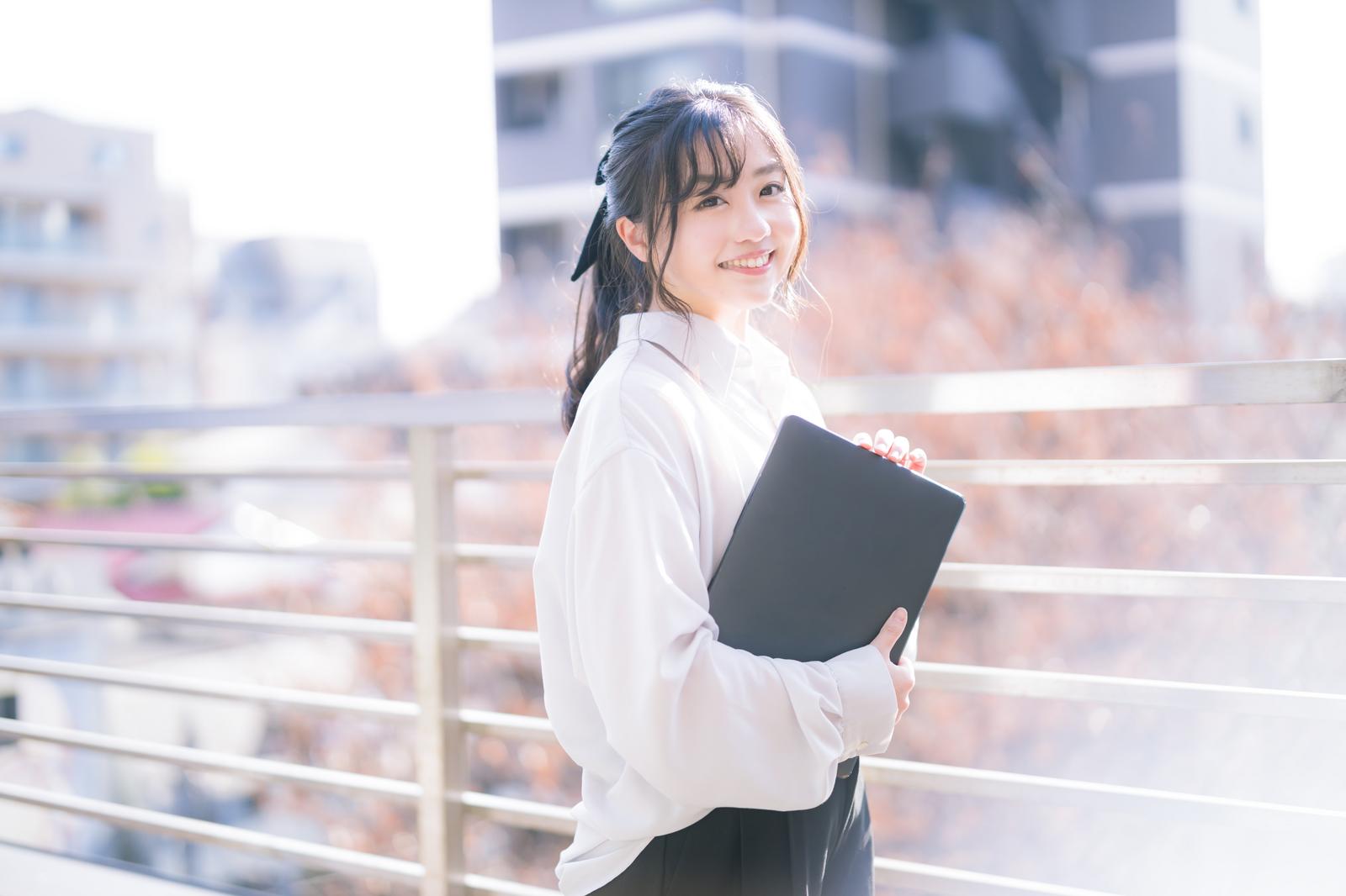 タブレットを持って屋上で笑顔の女性エンジニア［モデル：河村友歌］