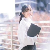 タブレットを持ってビルの屋上で微笑む女性エンジニアの写真