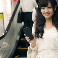 財布や定期券を出さずにスマートフォンで駅の改札を出る女性の写真
