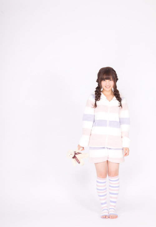 テディーベアを抱くボーダー柄パジャマ姿の女性