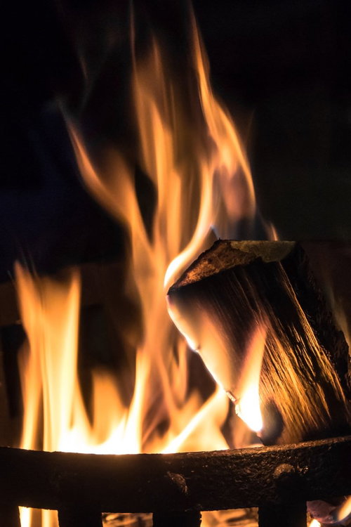 暗い場所で黄色とオレンジの炎が上がる燃える薪の篝火