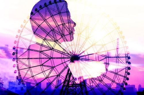 夕暮れの紫色の空に映る観覧車と手をつなぐ君のシルエット