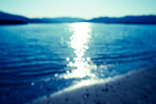 夏の海面に広がる太陽の光（ボケ）
