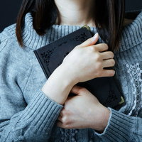 大切な思い出ノートを抱きしめる女性の切ない瞬間の写真