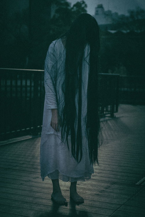 屋外デッキに這いつくばるホラーの女性