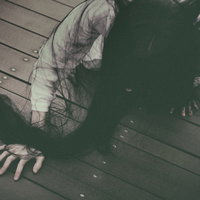 薄暗い木の床をどこまでも這い続ける髪の長い女性の写真