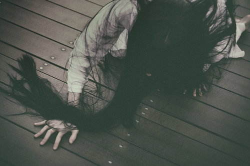 薄暗い木の床をどこまでも這い続ける髪の長い女性