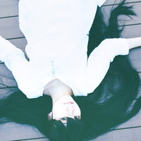 床に倒れ込む髪の長い女性の写真