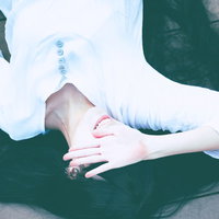 日差しを嫌がる色白彼女が仰向けに寝転んで日光を遮るの写真