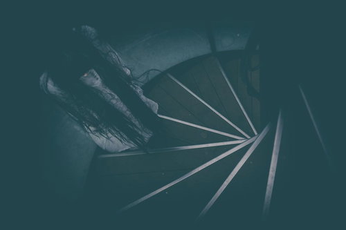 螺旋階段に立ちすくむ不気味な女性のシルエット