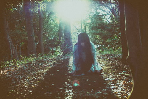 暗い森の中で蹲りながらこちらを睨みつける女性