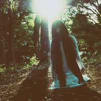 膝をついて恨めしい表情でこちらを見つめる女性の写真