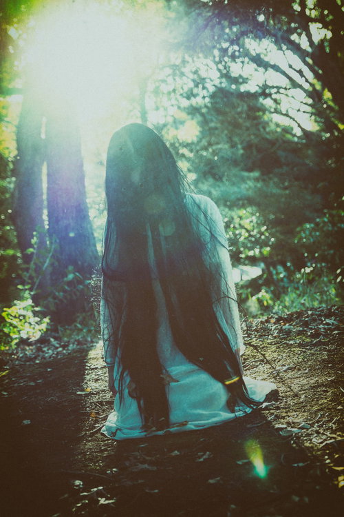 森の中で膝から崩れ落ちる女性