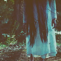 立ち上がりゆっくりとこちらに近づこうとする女性の足元の写真