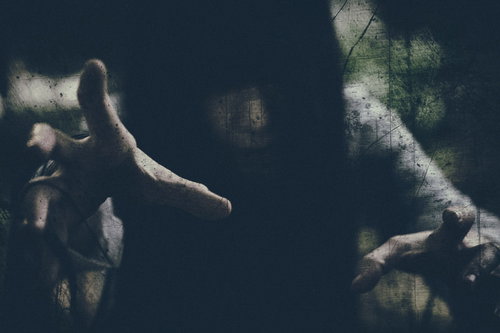 暗闇で呪いをかける女性の手と怨念の恐怖表現