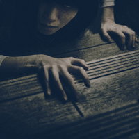 暗い階段に爪を立ててこちらを睨みつける女性の写真