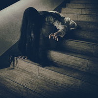 階段を下りるのに伸びた黒髪が邪魔になる女性の写真