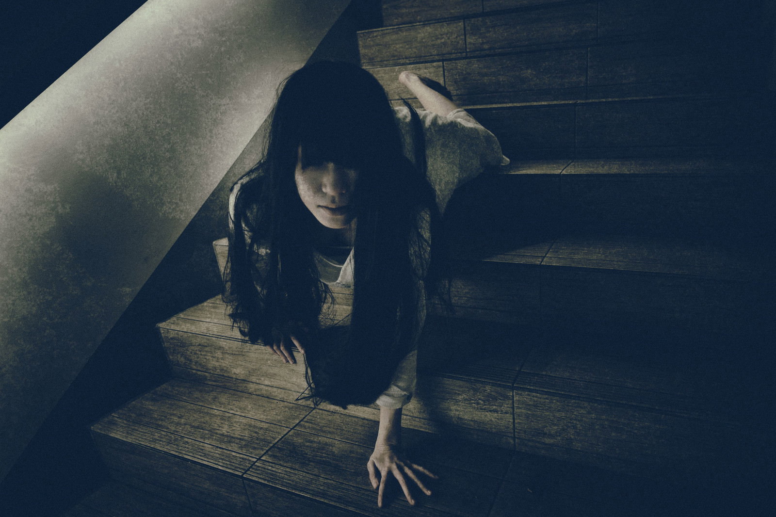 薄暗い階段で這いながらこちらに向かってくる長い髪の女性［モデル：緋真煉］