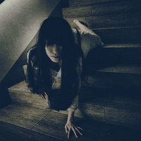 薄暗い階段を這いながら下りてこちらに向かってくる女性の写真