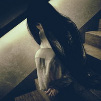 階段に蹲り恨めしそうに見上げる女性の怨念の写真