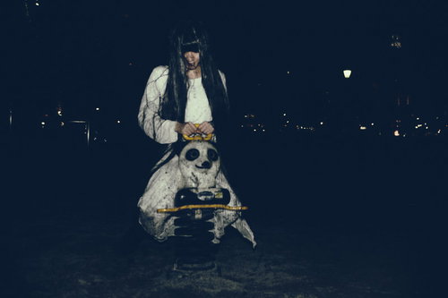 暗い公園でパンダ遊具に座る長い髪の女性の不気味な雰囲気