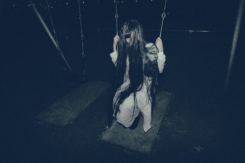 暗闇で失恋の悲しみに揺られる白い衣装の女性