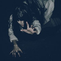 這い蹲りながら恨めしそうに掴みかかろうとする女性の写真