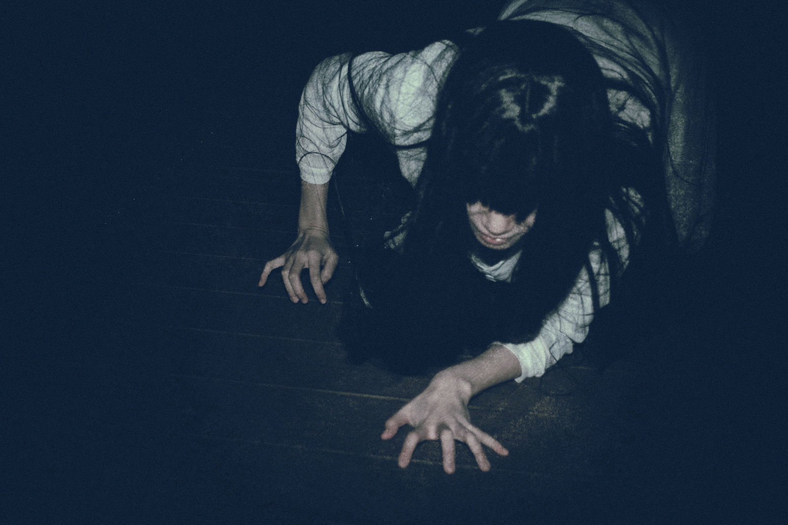 暗闇の中で白い衣装を着て這いつくばる女性［モデル：緋真煉］