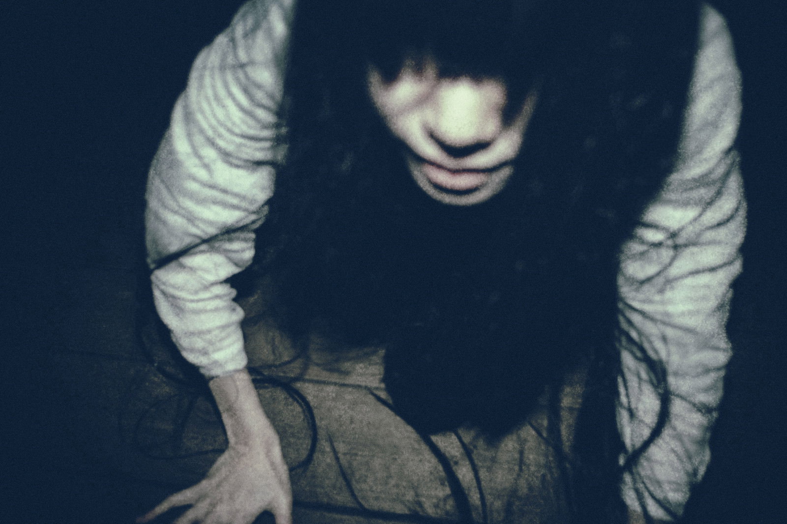 暗闇の中で這い上がる長い黒髪の女性の姿［モデル：緋真煉］