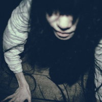暗闇の中で急接近する髪の長い女性が這い上がる恐怖シーンの写真