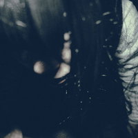 薄暗い空間で睨みつける不気味な女性の顔と長い髪の写真