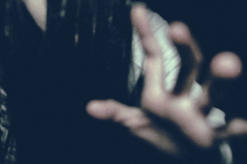 暗闇から現れ掴みかかろうとする女性のシルエット