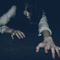 暗闇で両手を伸ばして絶対に許さない女性のシルエットの写真