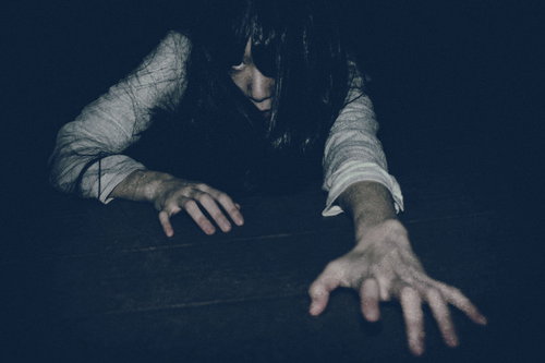 暗闇で両手を伸ばして絶対に許さない女性のシルエット