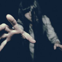 未練を残し現世にしがみつこうとする亡霊の女性の写真