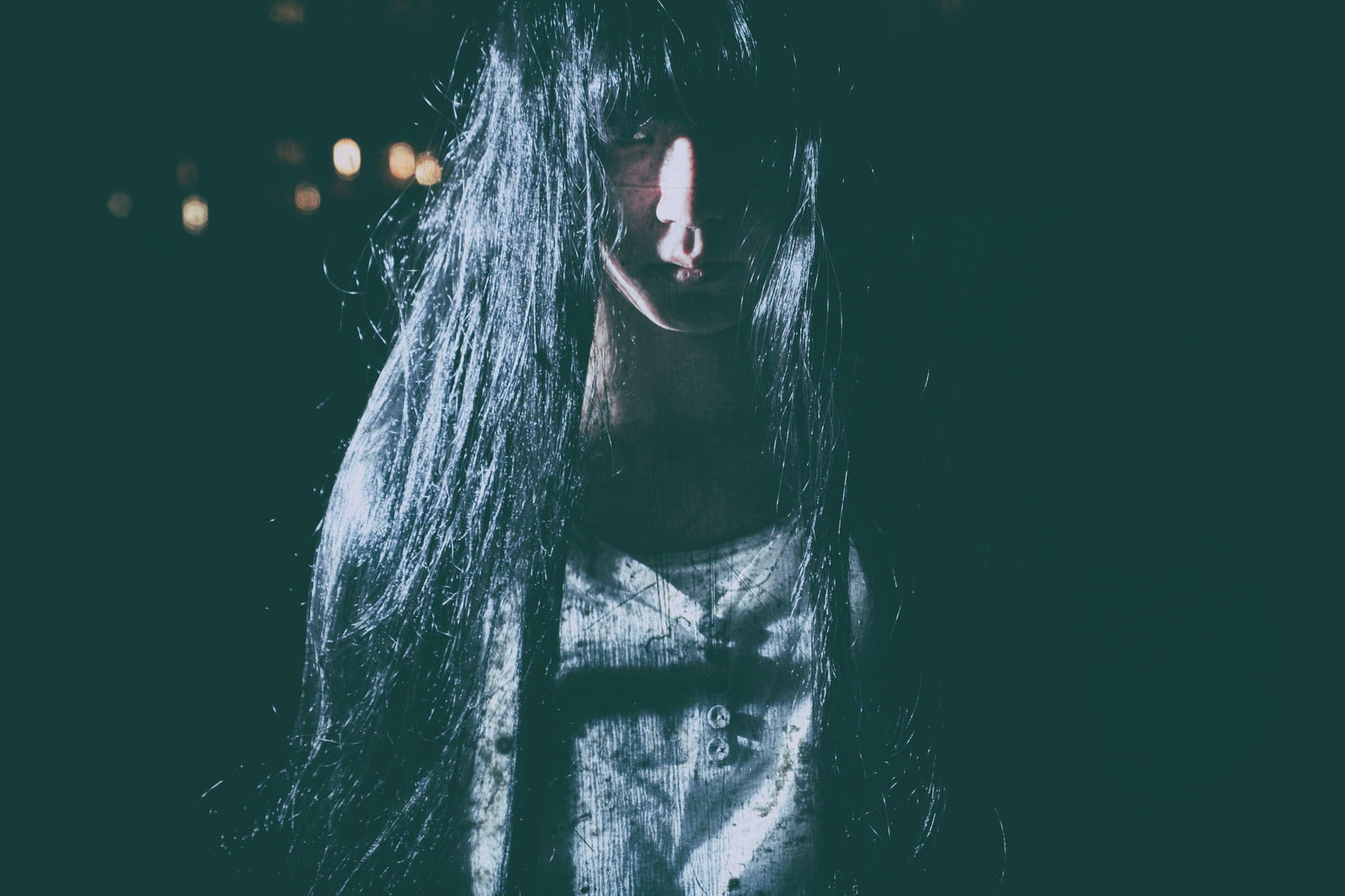 黒髪で顔を隠し暗闇に立つ女性［モデル：緋真煉］