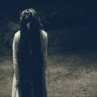 暗い空間に立ちすくむ怨念の女性：ホラー・心霊写真の写真