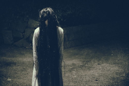 暗い空間に立ちすくむ怨念の女性：ホラー・心霊写真