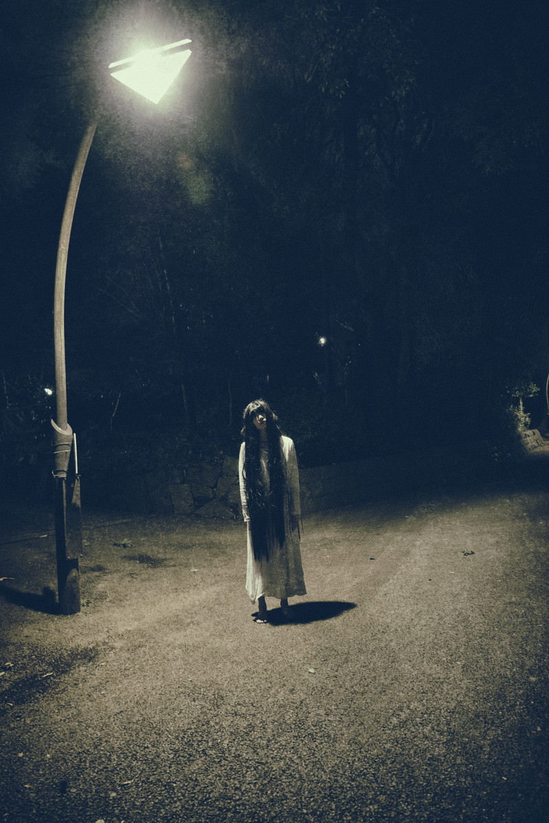 真夜中の公園の街灯の下で仁王立ちする裸足の女性［モデル：緋真煉］