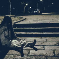 捨てられた人形のように階段に座り込む女性の姿の写真