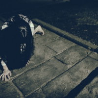 何かに取り憑かれた女性が石畳を這いつくばるの写真