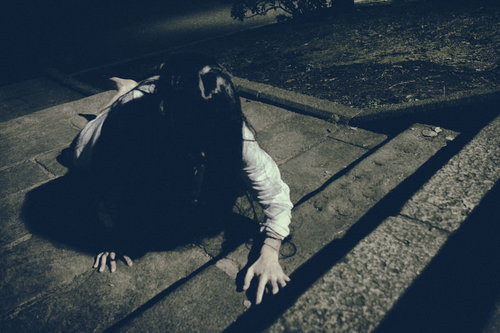 石の階段を這い蹲りながら上ろうとする女性