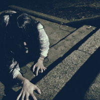 階段を這いつくばる未練を残した女性の怨念の写真