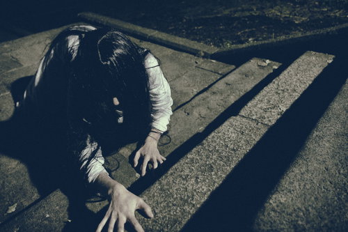 階段を這いつくばる未練を残した女性の怨念